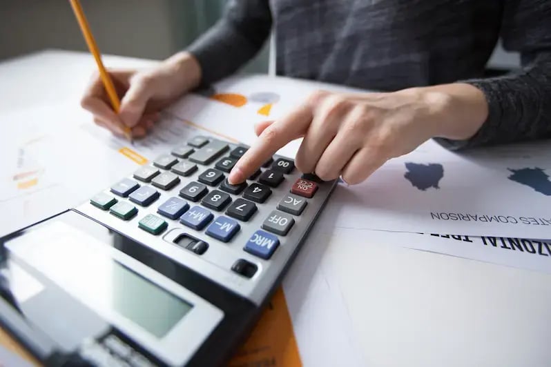 Imagem de uma pessoa calculando um faturamento